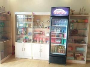a cocacola refrigerator in a room with white cabinets at 7Days Inn Yantai Development Zone Beach in Yantai