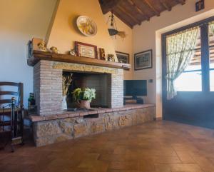 a living room with a brick fireplace with a window at CASE&COLLINE Casa Giulia in Guardistallo