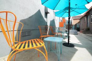 - un groupe de chaises et une table avec un parasol dans l'établissement Venice Beach Apartments Monthly rents, à Los Angeles