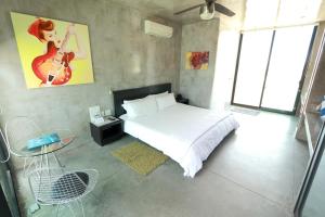 1 dormitorio con cama, mesa y guitarra en la pared en Vidasoul en Boca de la Vinorama