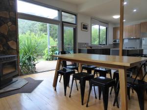a kitchen and dining room with a wooden table and chairs at Dacelo in Halls Gap