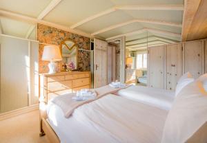 a bedroom with a large white bed and a mirror at Chalet Irene in Wengen