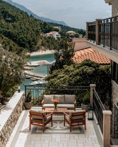 d'une terrasse avec un canapé et des chaises sur un balcon. dans l'établissement Villa AMore Brela, à Brela