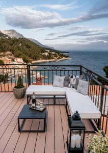 a white couch on a deck with a view of the ocean at Villa AMore Brela in Brela