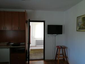 a room with a door open to a kitchen with a television at Apartment Bućić in Zlatibor