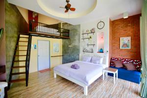 a bedroom with a bed and a spiral staircase at TonSilp Art Home in Nong Nam Daeng