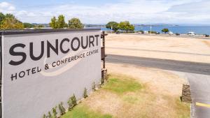 a sign for a hotel and conference center next to a road at Suncourt Hotel & Conference Centre in Taupo