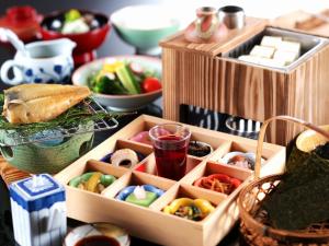 una mesa cubierta con cajas de madera llenas de diferentes tipos de comida en Onishiya Suishoen en Toyooka