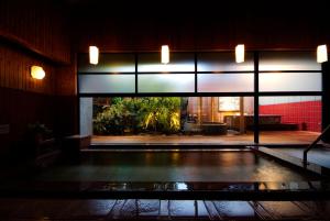 a room with a pool in the middle of a building at Onishiya Suishoen in Toyooka