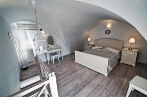 a room with a bed, a refrigerator, and a window at Archontiko Suites Santorini in Fira