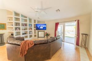a living room with a leather couch and a tv at Relax in style!! Pool, Vegas games, RV parking in Las Vegas