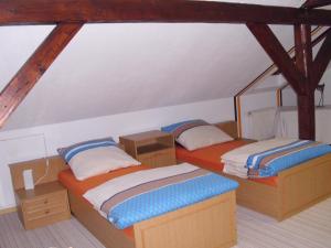 two twin beds in a room with wooden beams at Ferienwohnung Am Dorfplatz in Lutherstadt Wittenberg