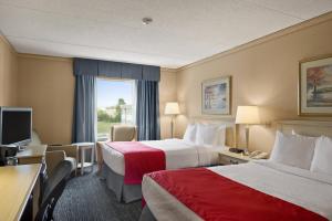 um quarto de hotel com duas camas e uma televisão em Ramada by Wyndham Trenton em Trenton