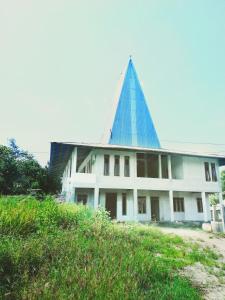 a building with a pyramid shaped roof on top of it at Lambo home stay in Waikabubak