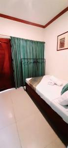 a bedroom with two beds and a green curtain at Brazaville Beach Resort in Hinoba-an
