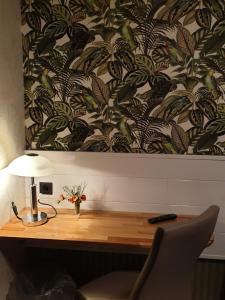 a desk with a lamp on top of it with a wallpaper at Waldhotel Lemberg in Hagen