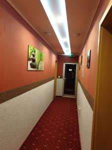 un corridoio con tappeto rosso e un corridoio con corridoio di Waldhotel Lemberg a Hagen