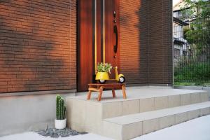 a flower pot sitting on a bench in front of a house at Muji House Osaka Sannan Hotel 大阪泉南酒店良築 in Tannowa