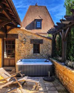 una bañera de hidromasaje en el patio trasero de una casa en La Closerie de Baneuil en Baneuil