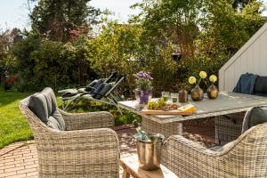 a patio with a table and wicker chairs at Techts Apartmenthaus in Timmendorfer Strand