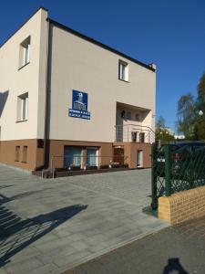 a large white building with a blue sign on it at LATARNIK in Władysławowo