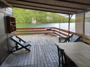 una terraza de madera con mesa y sillas en un barco en Raft Perućac, en Rastište