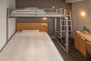 a small room with a bunk bed with a ladder at Super Hotel JR Ueno Iriyaguchi in Tokyo