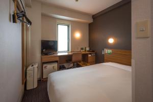 Un pat sau paturi într-o cameră la Super Hotel JR Ueno Iriyaguchi