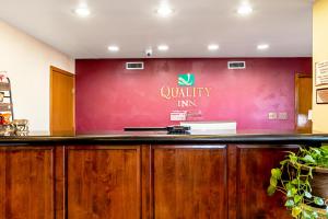 a bar at aquality inn with a red wall at Quality Inn in Three Rivers