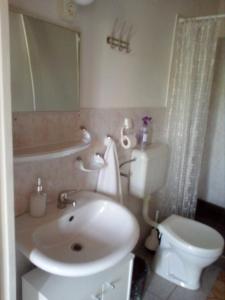 łazienka z białą umywalką i toaletą w obiekcie Nosztalgia Vendégház w Bogácsu +33 zdjęcia
