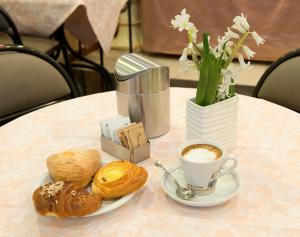 einen Tisch mit einer Tasse Kaffee und einem Teller Gebäck in der Unterkunft Hotel Careggi in Florenz