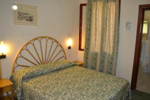 a small bedroom with a bed and a window at Hotel Danila in Portoferraio