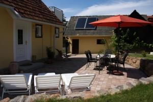 a patio with a table and chairs and an umbrella at Ferienhaus am Meisslberg in Bad Gleichenberg