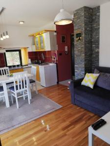 uma sala de estar com um sofá azul e uma cozinha em Smiley 1 em Divčibare