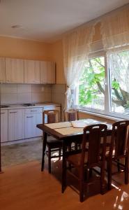 a kitchen with a table and chairs and a window at Apartmani Smiljanic Sokobanja in Soko Banja