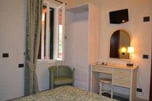 a bedroom with a desk and a chair and a mirror at Hotel Danila in Portoferraio