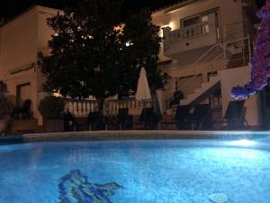 a swimming pool in front of a building at night at Casa Pani in Empuriabrava