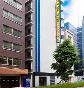 un edificio alto con un árbol delante de él en Super Hotel JR Ueno Iriyaguchi, en Tokio