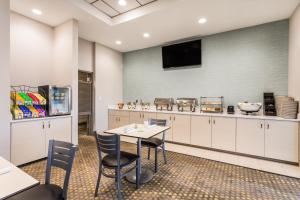 a kitchen with a table and chairs and a tv at Holiday Inn Timonium, an IHG Hotel in Timonium