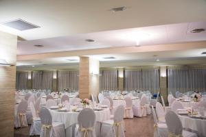 a banquet hall with white tables and chairs at Hotel Universidad in Albacete