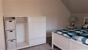 a small bedroom with a bed and white cabinets at Ferienhaus "Villa am Eck" in Eichenzell