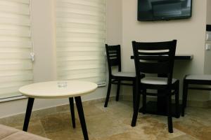 a table and chairs in a room with a tv at Apartments Vila Monegro in Bar