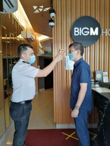two men wearing masks are standing in a store at BIG M Hotel in Kuala Lumpur