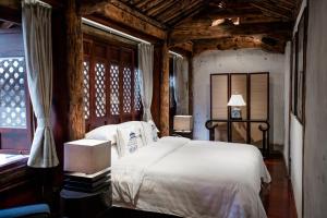 a bedroom with a white bed and a window at Dali Sky Valley Heritage Boutique Hotel in Dali +53 photos