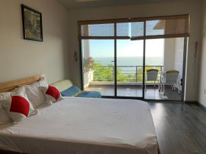a bedroom with a bed with a view of a balcony at Bella Vista Vung Tau in Vung Tau