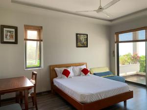 une chambre avec un lit, un bureau et des fenêtres dans l'établissement Bella Vista Vung Tau, à Vung Tau 25 autres photos