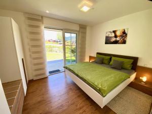 ein Schlafzimmer mit einem Bett und einem großen Fenster in der Unterkunft Ferienwohnung Winklmoos in Schönau am Königssee