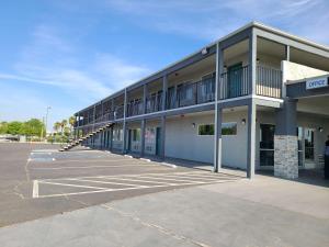 an empty parking lot in front of a building at SureStay Hotel by Best Western Chowchilla Yosemite in Chowchilla