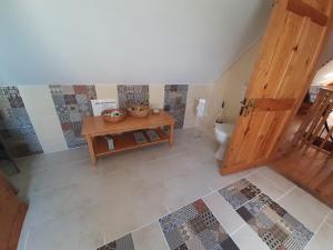 ein Bad im Dachgeschoss mit einem WC und einem Tisch in der Unterkunft Driftwood Country Apartment in Skibbereen