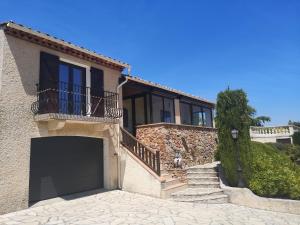 une maison avec une porte de garage et un balcon dans l'établissement Villa ANTINEA, A SAINT AYGULF, PISCINE PRIVEE, VUE MER PANORAMIQUE, à Fréjus